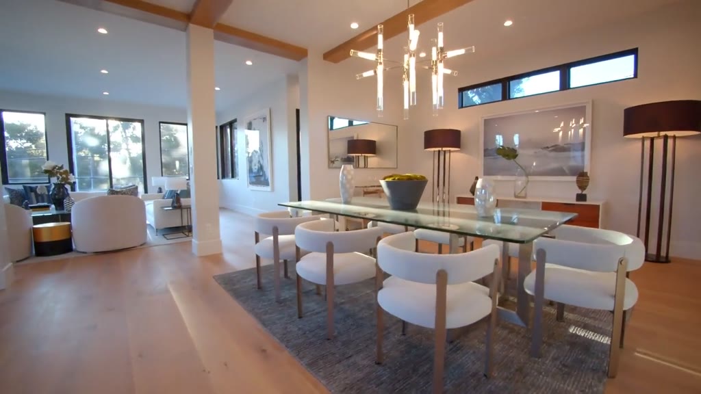 Salon lumineux avec grande table et chaises blanches